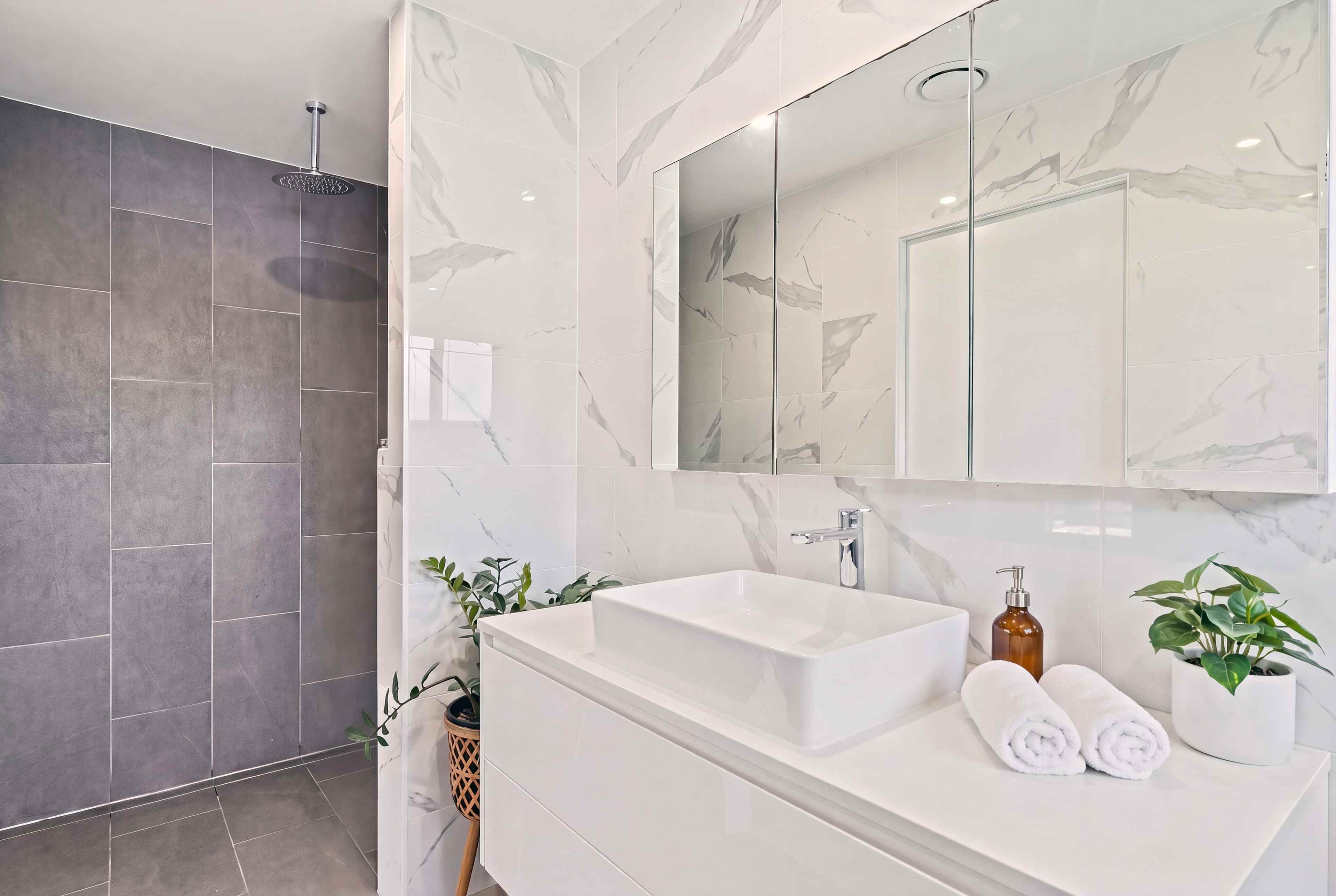 Ensuite with marble-look tiles, a white floating vanity and a vessel basin