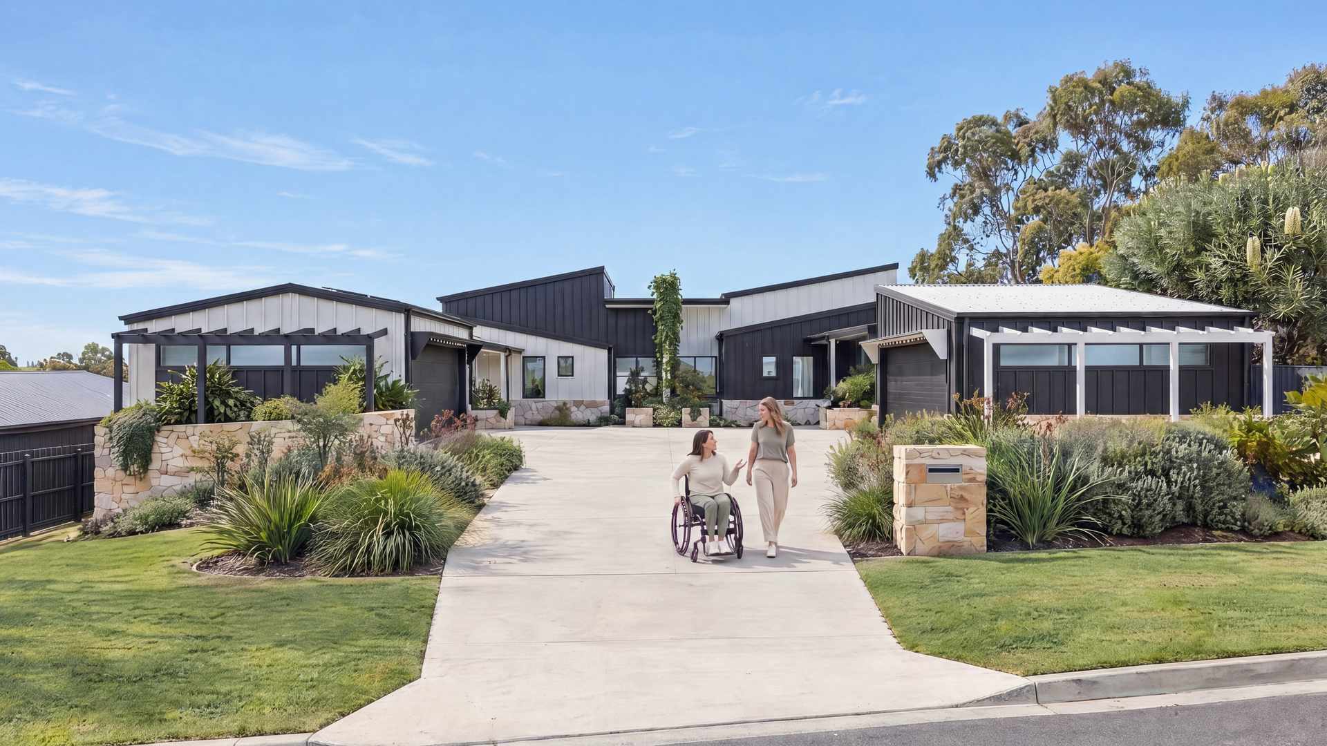 Single-level SDA homes with a level driveway, where a resident using a wheelchair and a friend head out together