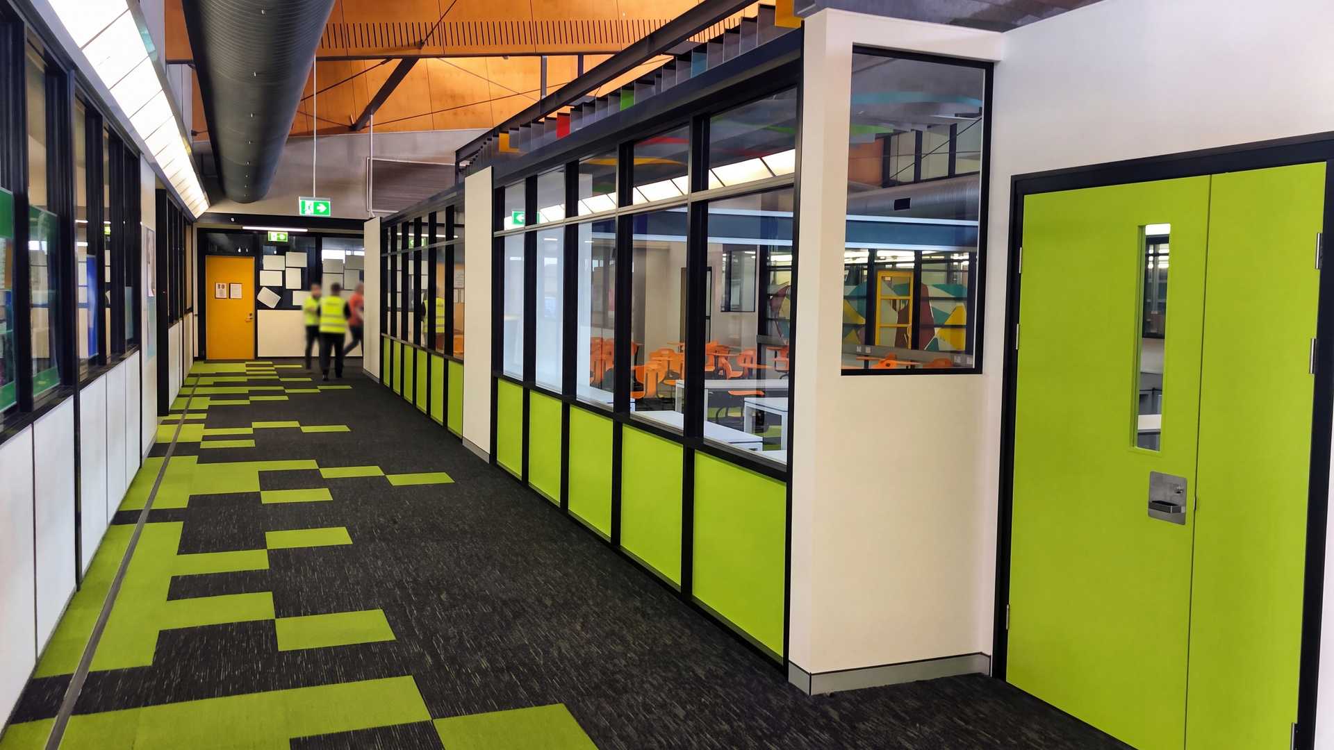 A newly finished school corridor with lime-green doors and glazed classrooms